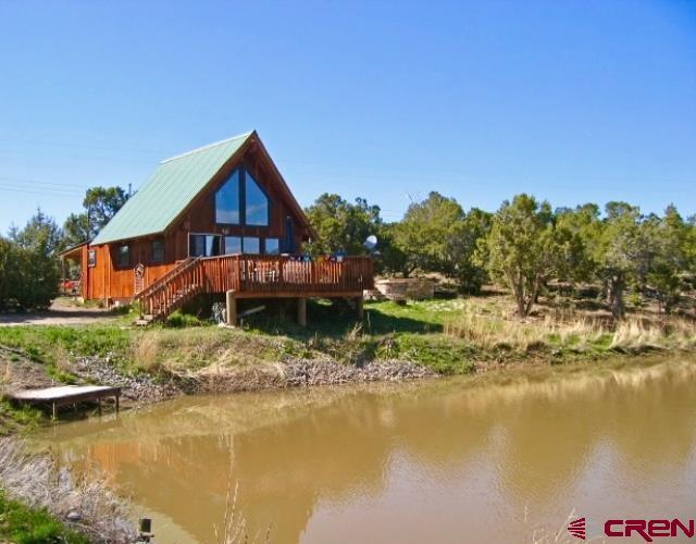 rear view of property with a deck with water view