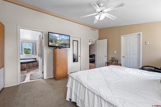 bedroom featuring ceiling fan, light colored carpet, and ensuite bath