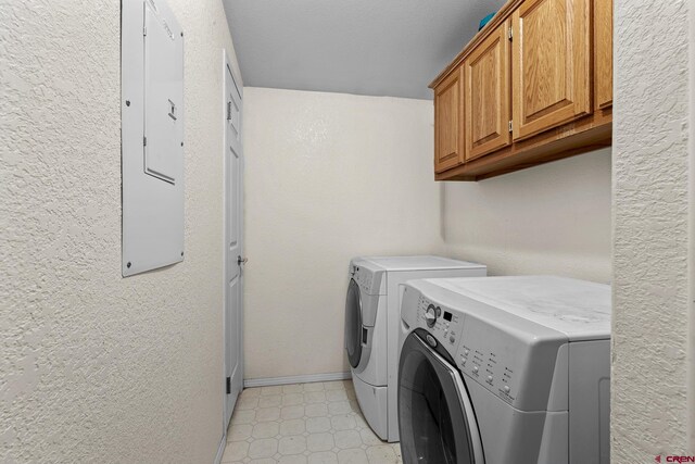 laundry area featuring cabinets, electric panel, and separate washer and dryer