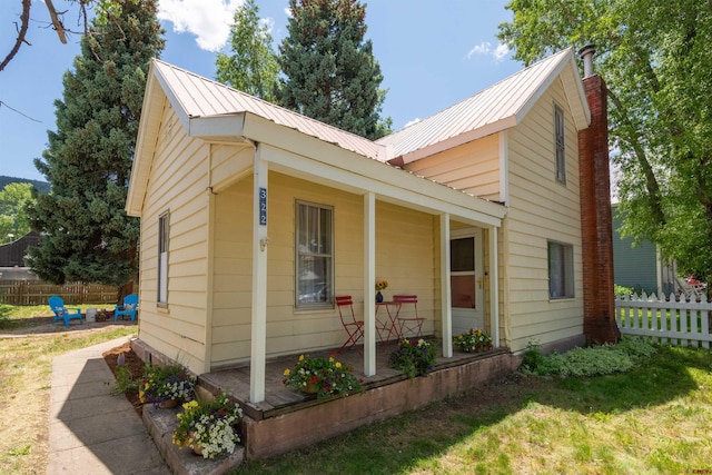 view of side of home featuring a lawn and covered porch