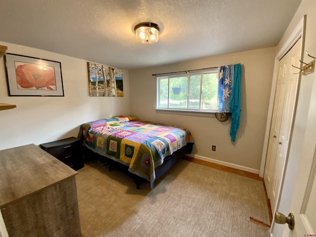 bedroom featuring a textured ceiling, baseboards, and a closet