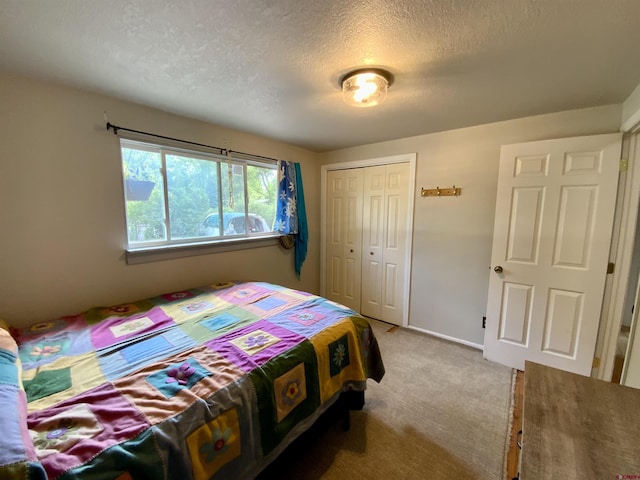 carpeted bedroom featuring a textured ceiling and a closet