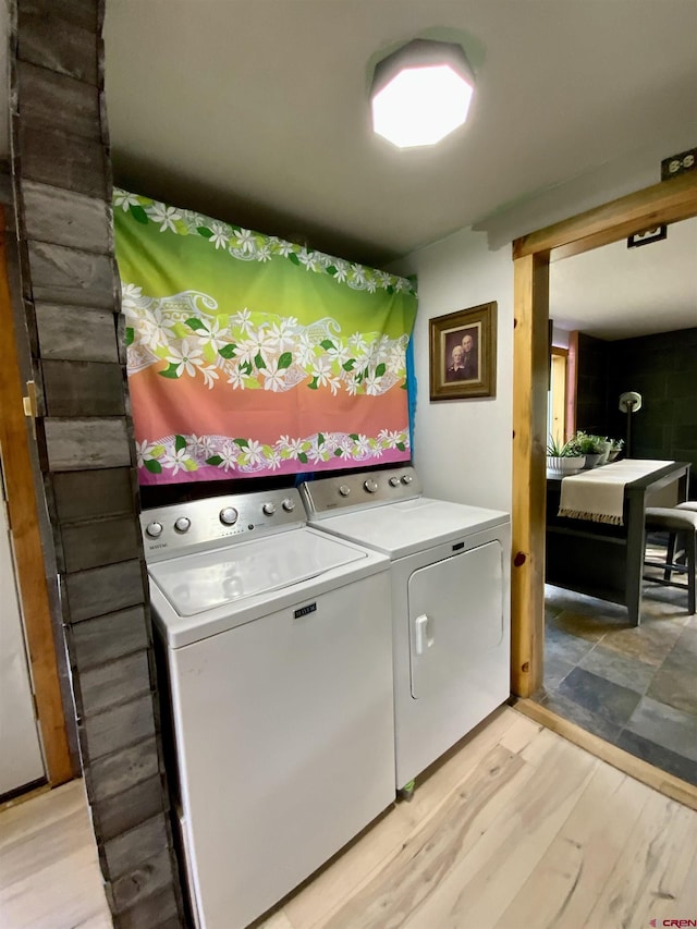 laundry room featuring laundry area, light wood-style flooring, and separate washer and dryer