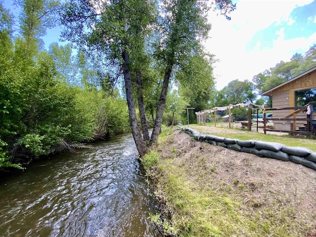 view of yard with a water view and fence