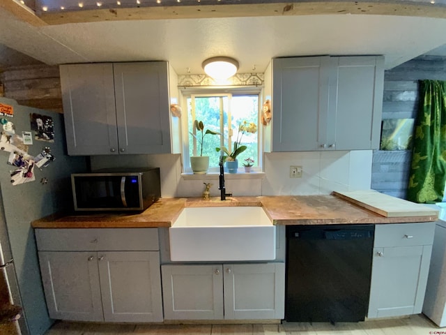 kitchen with a sink, stainless steel appliances, and wood counters