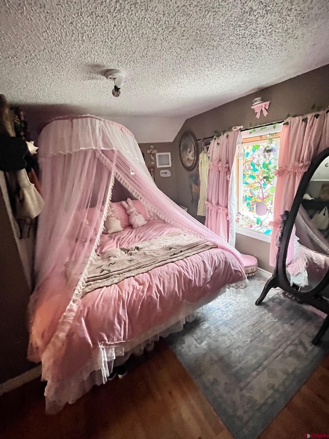 bedroom featuring hardwood / wood-style flooring and a textured ceiling