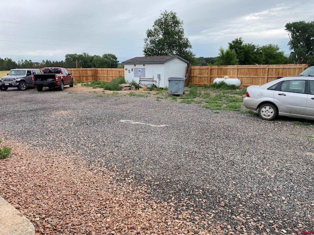 view of yard featuring an outbuilding, a shed, and fence