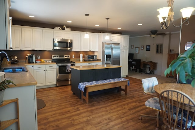 kitchen featuring dark hardwood / wood-style floors, decorative light fixtures, ceiling fan with notable chandelier, sink, and appliances with stainless steel finishes