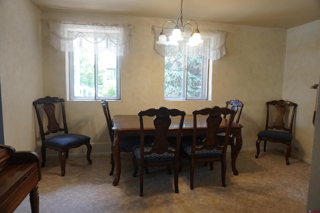 carpeted dining area with an inviting chandelier