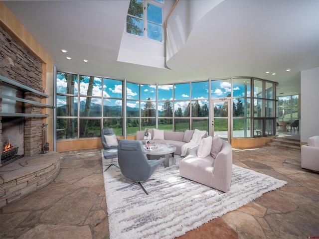 sunroom / solarium featuring a stone fireplace