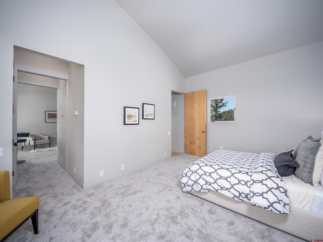 bedroom with carpet floors and high vaulted ceiling