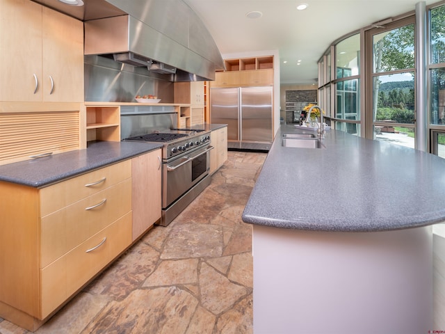 kitchen featuring light brown cabinetry, sink, extractor fan, high end appliances, and a kitchen island with sink