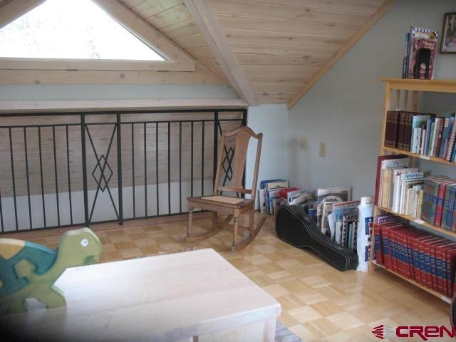 living area with parquet floors, vaulted ceiling, and wooden ceiling