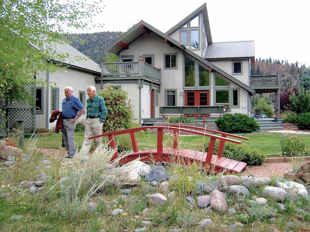 view of front facade featuring a front lawn and a balcony