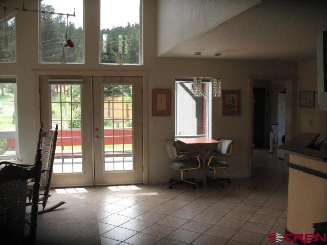 doorway to outside with tile floors, a wealth of natural light, and french doors