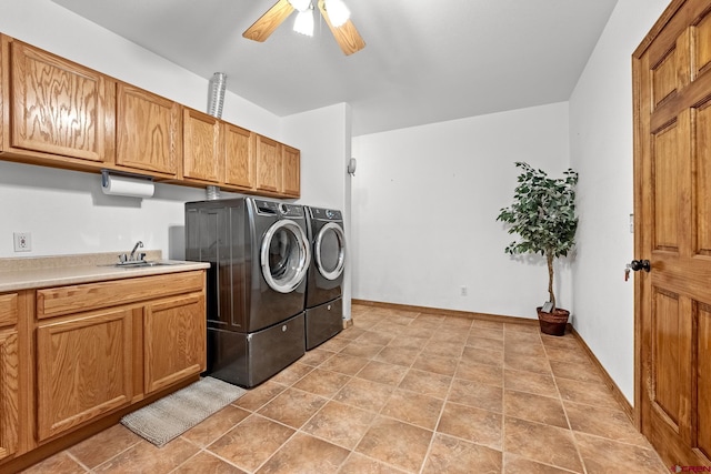 laundry room featuring ceiling fan, light tile flooring, washing machine and dryer, sink, and cabinets