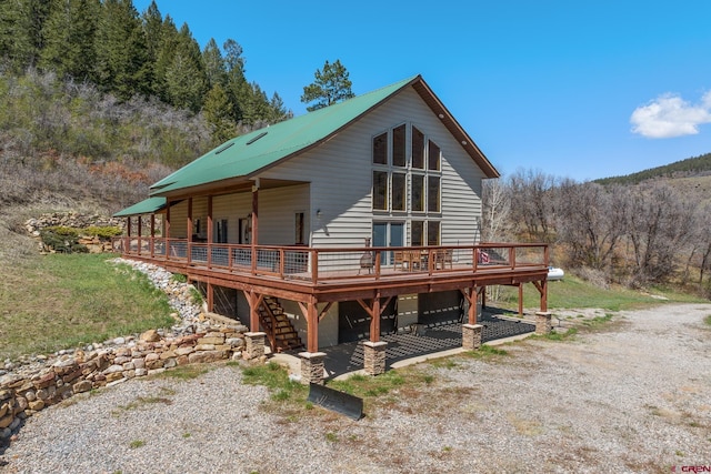 26 Severn Peak Rd, Bayfield, CO 81122 - view of front of house with a wooden deck, a view of trees, and gravel driveway