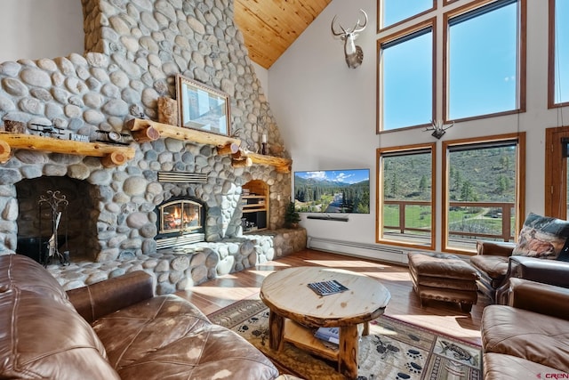 living room with hardwood / wood-style floors, a stone fireplace, high vaulted ceiling, baseboard heating, and wood ceiling