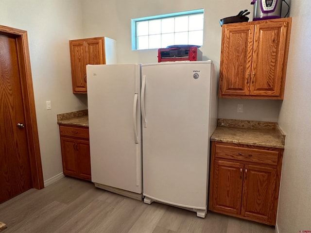 kitchen with white refrigerator and light wood-type flooring