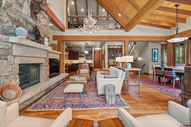 living room featuring an inviting chandelier, a fireplace, light hardwood / wood-style floors, and wooden ceiling