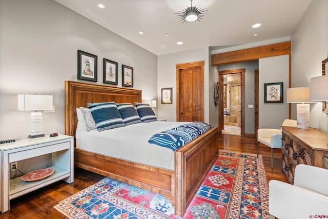 bedroom with ensuite bath and dark hardwood / wood-style flooring