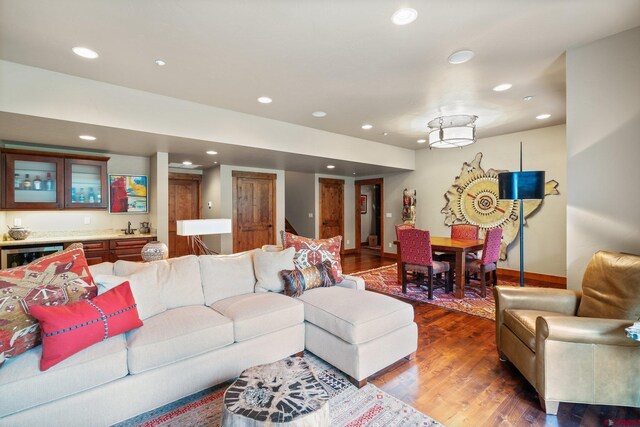 living room with dark hardwood / wood-style flooring and indoor wet bar