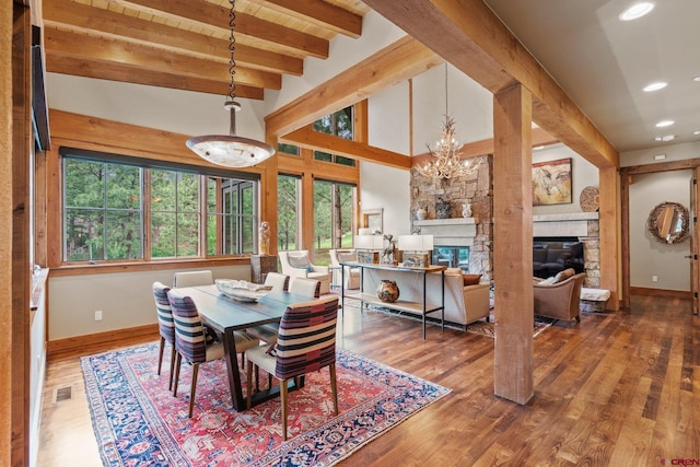 dining room with beamed ceiling, plenty of natural light, an inviting chandelier, and hardwood / wood-style flooring