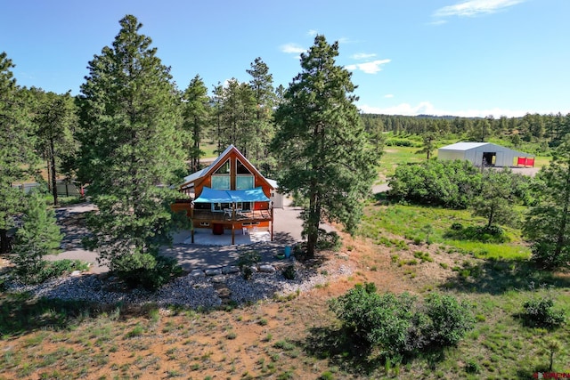 rear view of house featuring a forest view