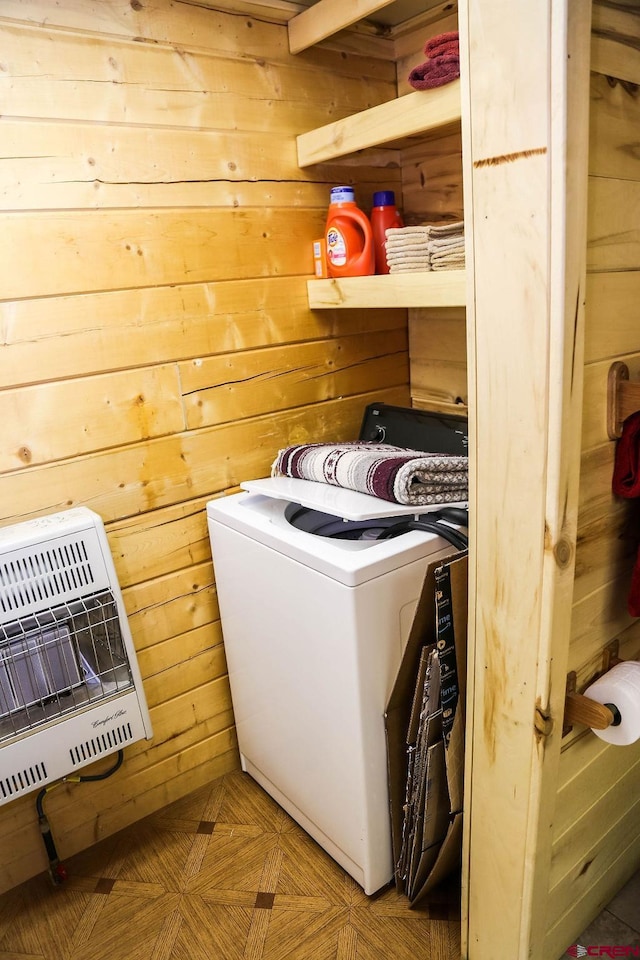 clothes washing area with washer / clothes dryer, light parquet flooring, and wooden walls