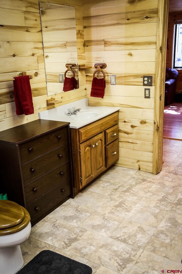 bathroom with vanity, wooden walls, and tile patterned floors