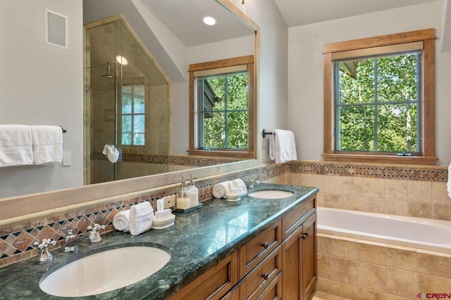 bathroom with dual vanity, a wealth of natural light, and independent shower and bath