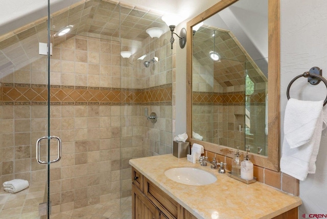 bathroom featuring a shower with shower door and vanity