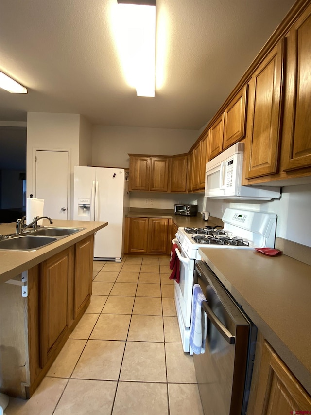 kitchen featuring sink, white appliances, a textured ceiling, and light tile patterned flooring