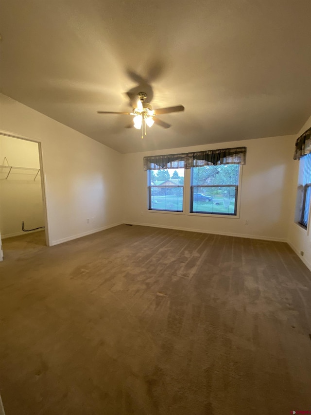 carpeted spare room featuring lofted ceiling and ceiling fan