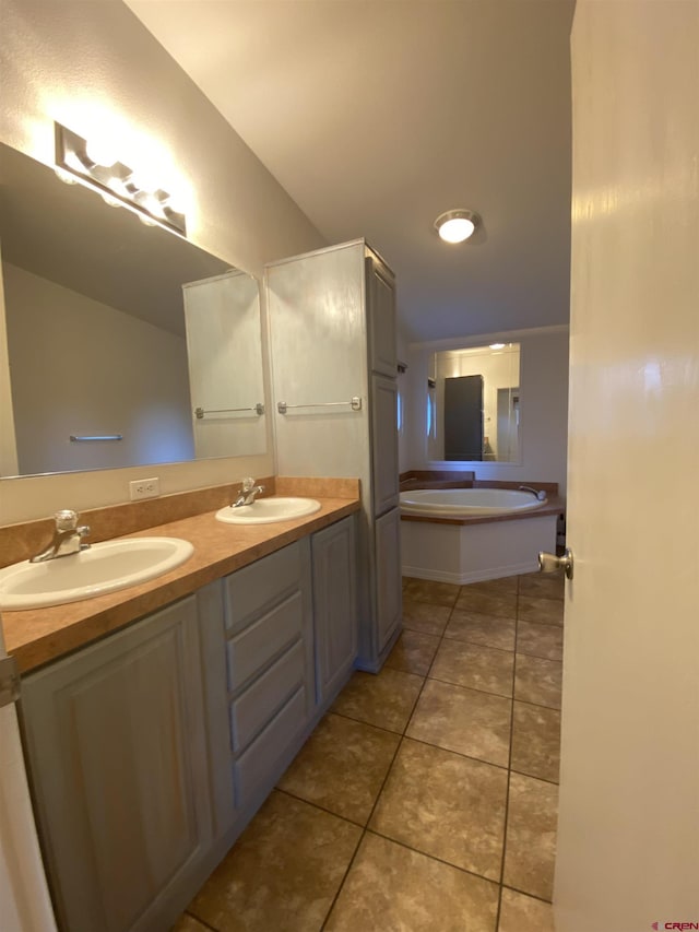 bathroom with vanity, a bath, and tile patterned floors