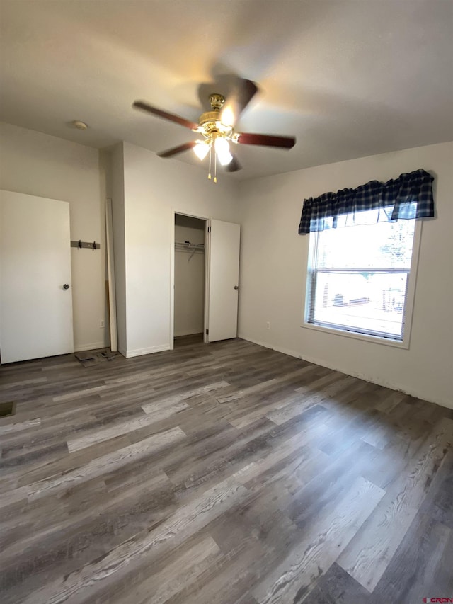 unfurnished bedroom featuring hardwood / wood-style floors, ceiling fan, and a closet