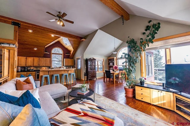 living room featuring lofted ceiling with beams, dark hardwood / wood-style flooring, and ceiling fan