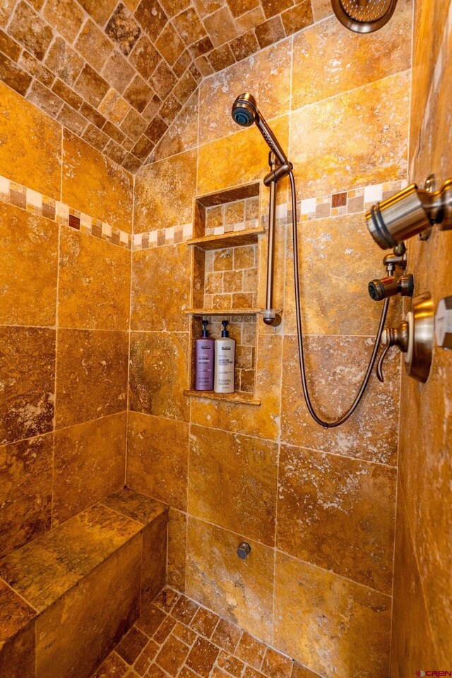 bathroom featuring tiled shower and vaulted ceiling