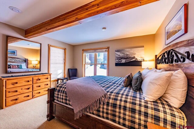 bedroom featuring beam ceiling and carpet flooring