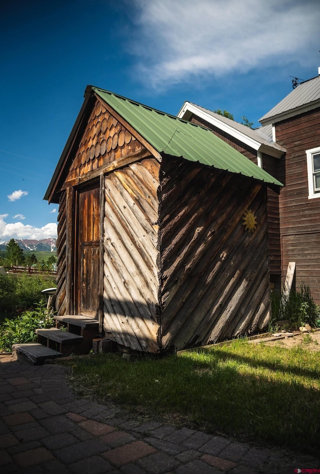 view of property exterior with a storage unit