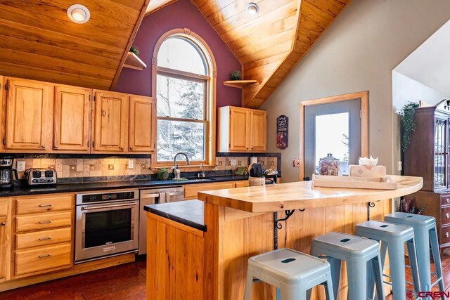 kitchen featuring wood ceiling, dark hardwood / wood-style flooring, backsplash, and stainless steel appliances