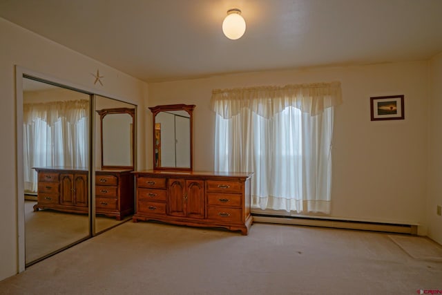 unfurnished bedroom featuring a closet, carpet, and baseboard heating