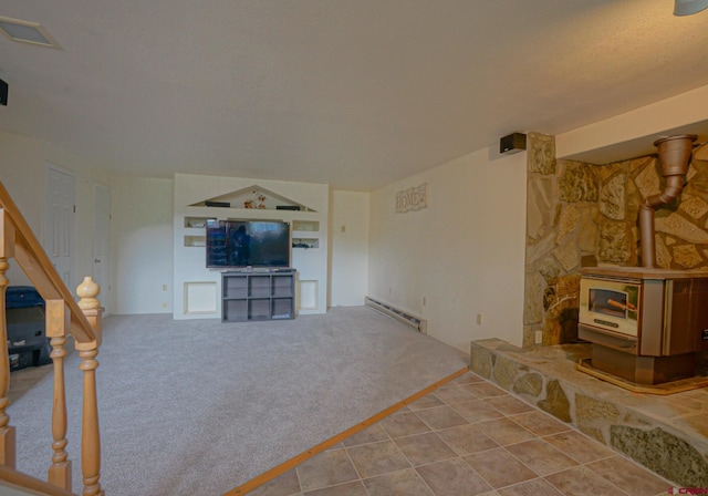 living room featuring a wood stove, a baseboard heating unit, and carpet