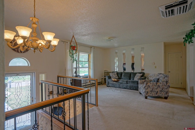 carpeted living room featuring a notable chandelier, a healthy amount of sunlight, a baseboard heating unit, and a textured ceiling