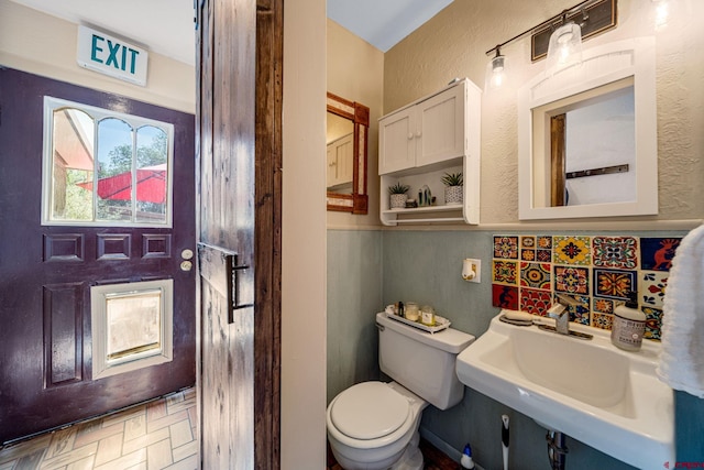 bathroom featuring sink, toilet, and tasteful backsplash