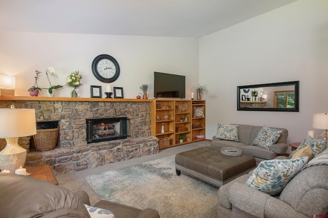 carpeted living room featuring a stone fireplace and lofted ceiling