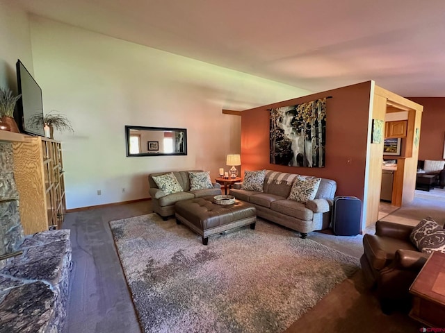 living room with a stone fireplace, baseboards, and vaulted ceiling