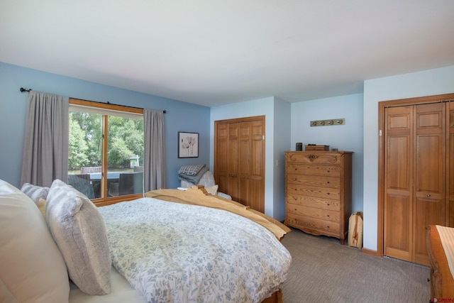 bedroom featuring access to exterior, two closets, and light carpet