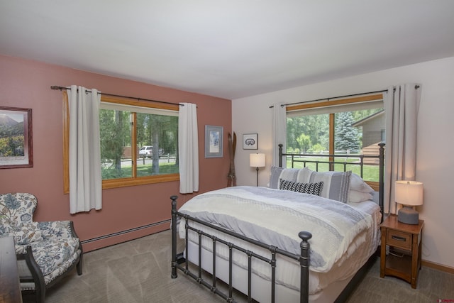 bedroom featuring a baseboard heating unit, multiple windows, carpet, and baseboards