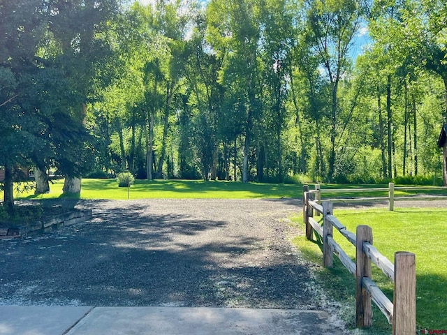 view of community with a lawn and fence